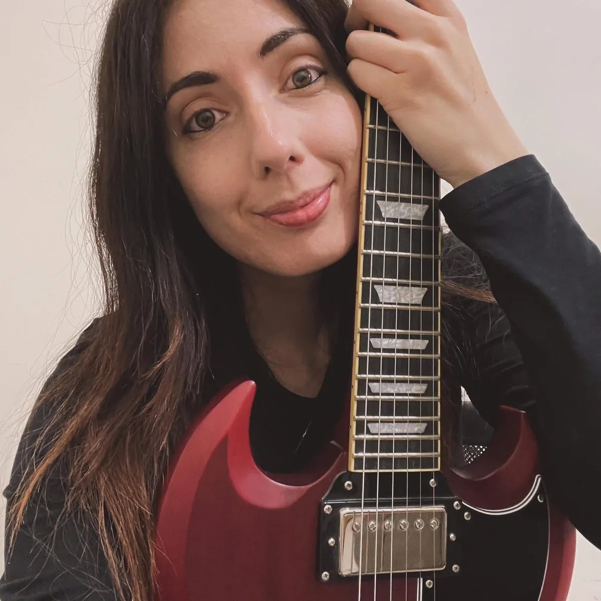 Portrait of Amy Lee holding an electric guitar to her face
